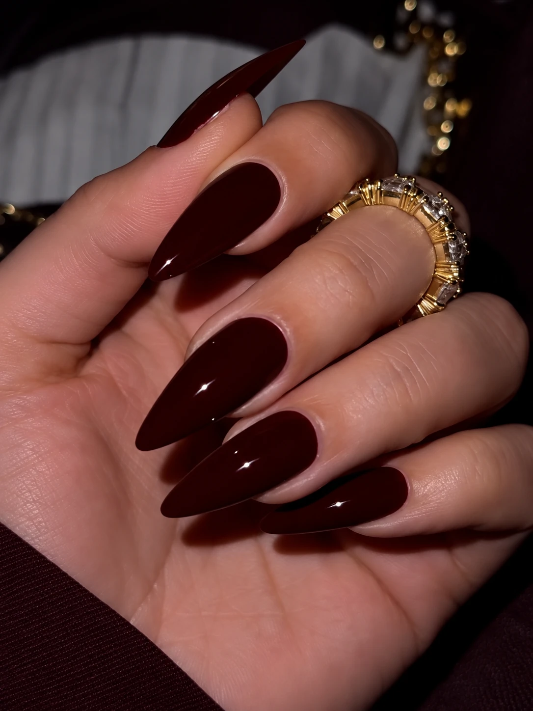 High-gloss dark burgundy stiletto press on nails showing a sharp tapered silhouette and rich lacquer finish